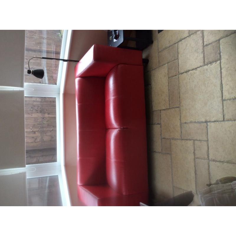 Two seater red faux leather sofa