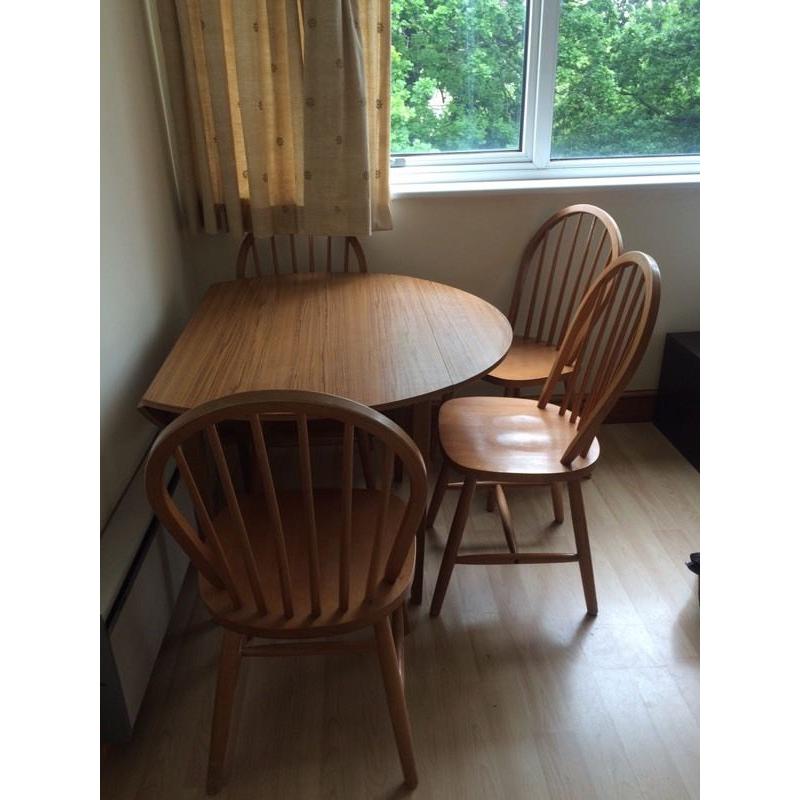 Dining table with drop leaf for space saving and four chairs.