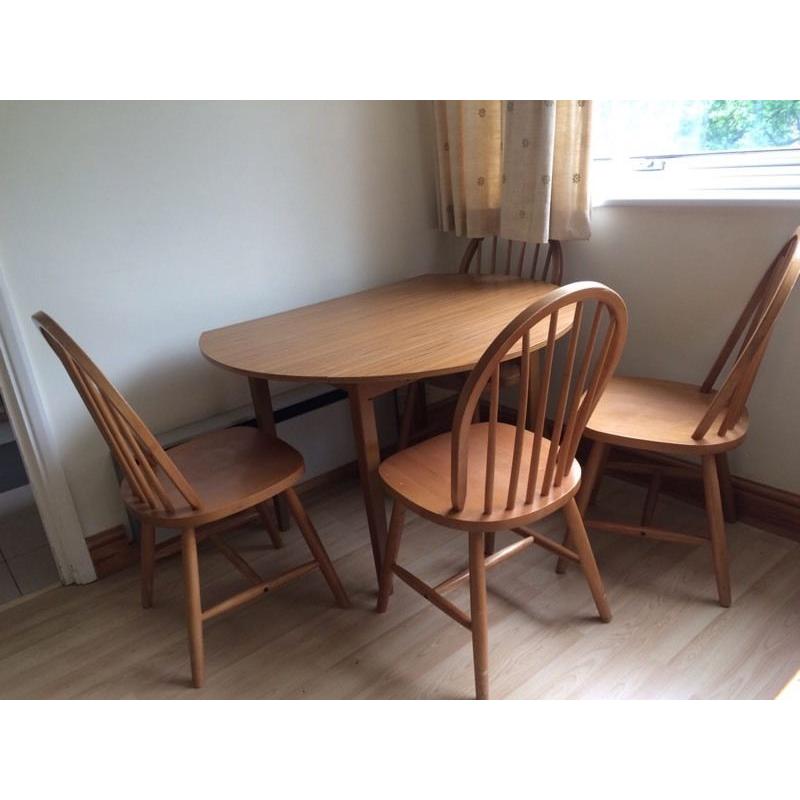 Dining table with drop leaf for space saving and four chairs.