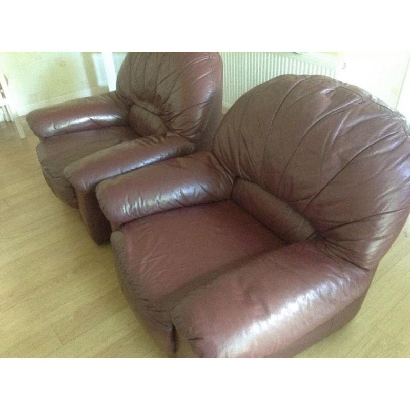 Two large burgundy leather armchairs in good condition.