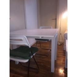 White dining table and two folding chairs